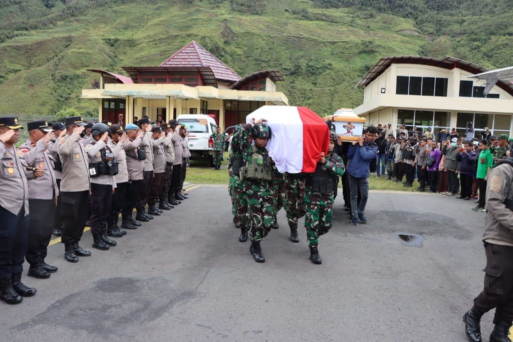Aparat Kepolisian Resor Puncak Jaya memberikan penghormatan terakhir bagi jenazah dua aparat keamanan, yakni Sersan Dua Riswar dan Bripda Mesak Indey, di Distrik Mulia, Kabupaten Puncak Jaya, Papua Tengah, Minggu (26/3/2023). Keduanya menjadi korban serangan kelompok kriminal bersenjata saat mengamankan shalat Tarawih di Distrik Ilu pada Sabtu (25/3/2023).
