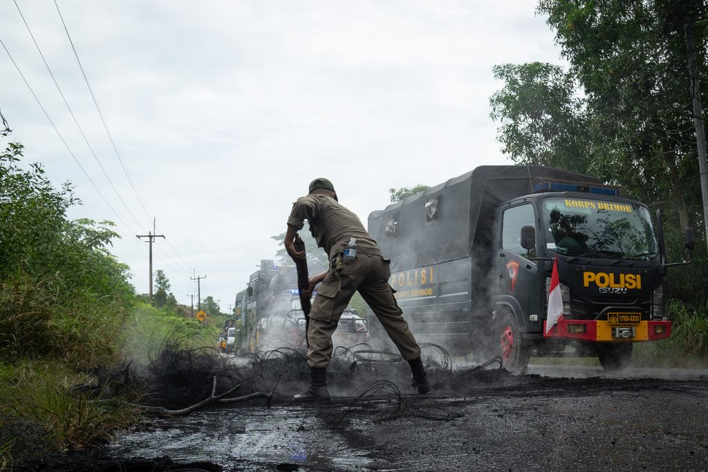 Petugas membersihkan pohon yang ditumbangkan dan dibakar warga untuk menghalangi aparat gabungan masuk ke Pulau Rempang, Batam, Kepulauan Riau, Kamis (7/9/2023).