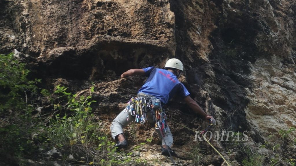 Yadi Tando yang menjadi <i>leader </i>pemanjatan di tebing Candi, daerah Klapanunggal, Bogor, memasang <i>runner </i>atau pengaman pemanjatan, Kamis (8/2/2024).