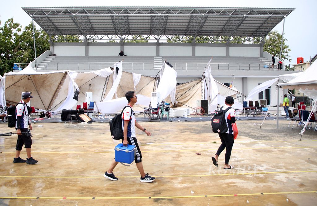 Atlet pulang dengan melewati di depan tenda tim peserta yang bertumbangan seusai Lapangan Panahan PON Aceh-Sumut 2024 di Kompleks Stadion Harapan Bangsa, Banda Aceh, Rabu (18/9/2024), dihantam hujan badai sekitar pukul 12.00. 