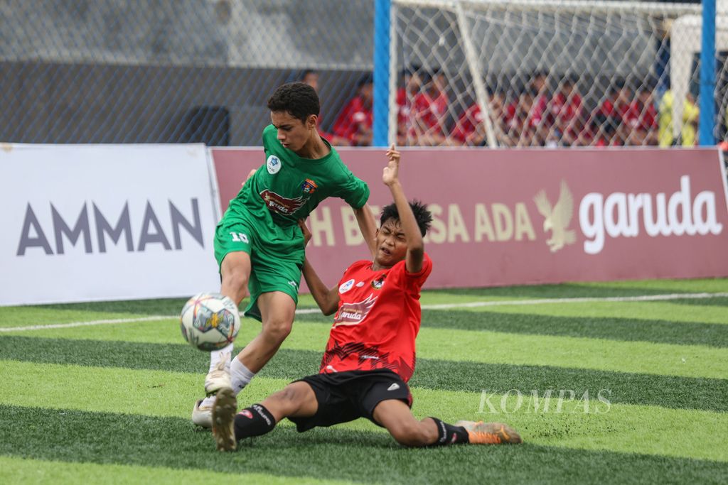 Pemain Putra Agung Faris Abqariyoris (kanan) menjegal pemain Buperta Cibubur Zahid Ash Shidqi pada pertandingan Liga Kompas Kacang Garuda U-14 di Dewantara Sport Center, Tangerang Selatan, Banten, Minggu, (28/1/2024). 