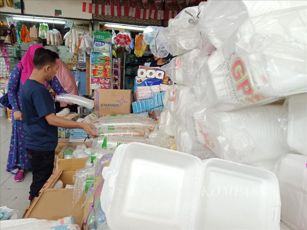 Pedagang gelas plastik dan tempat makanan stirofoam melayani pembeli. Bahan plastik dan strirofoam mengandung bahan berbahaya bagi manusia dan juga lingkungan.