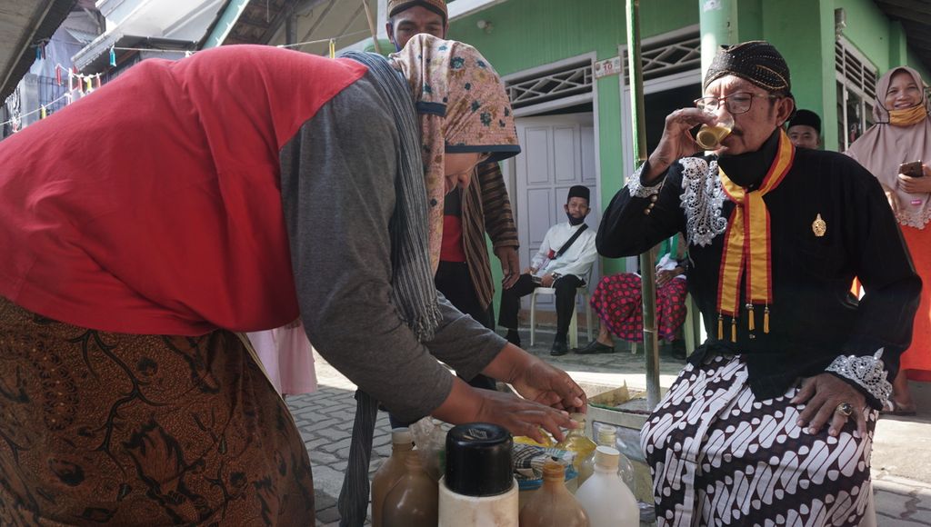 Tukang jamu gendong di RT 006 Keluharan Bumiwaras, Kecamatan Bumiwaras, Kota Bandar Lampung, Lampung, membagi-bagikan jamu untuk warga saat perayaan Hari Kemerdekaaan Ke-75 RI, Senin (17/8/2020). 