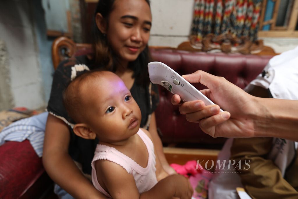 A doctor from the Kramatjati Sub-district Health Center accompanied by local posyandu cadres, dasawisma officers, and Kramatjati RT officials in East Jakarta, checked the body temperature of toddler children before administering immunizations by visiting homes, on Tuesday (22/11/2022).