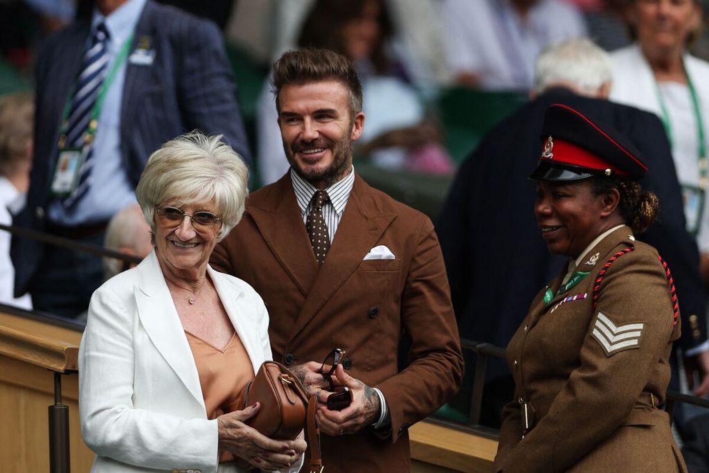 Mantan bintang timnas sepak bola Inggris, David Beckham (tengah), dan ibunya, Sandra Georgina West (kiri), menyaksikan laga perempat final Wimbledon dari tribune Royal Box di All England Tennis Club, Wimbledon, London, Rabu (6/7/2022). Laga itu dimenangi Simona Halep. 
