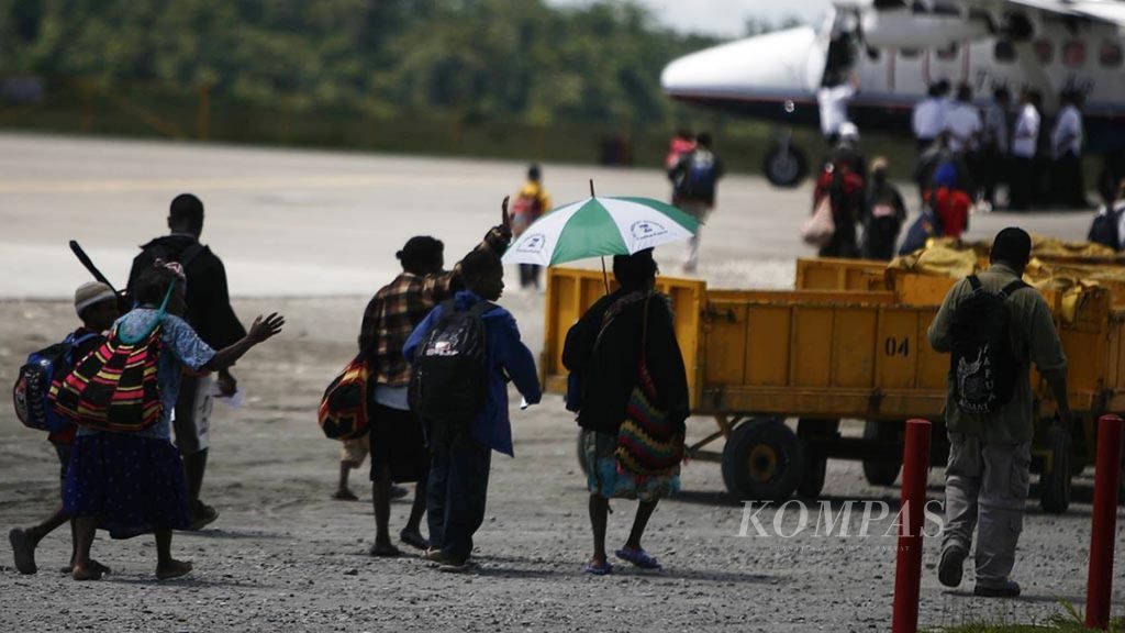 Warga Papua yang berasal dari daerah pegunungan berjalan menuju pesawat perintis untuk kembali ke kampung halaman mereka melalui Bandara Mozes Kilangin, Kabupaten Mimika, Papua, pertengahan Desember 2008.