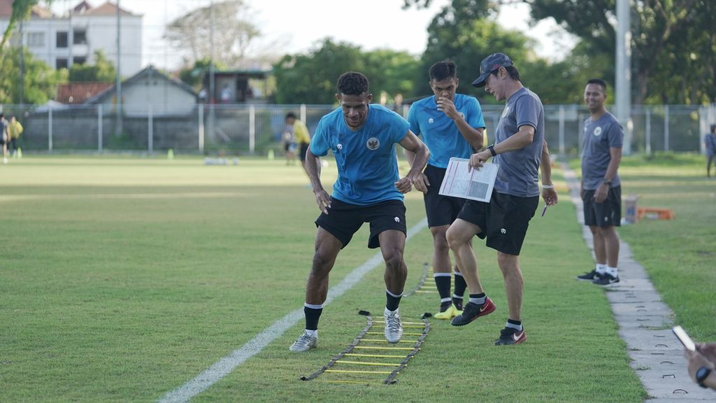 Pelatih Indonesia Shin Tae-yong (kanan) mengamati latihan <i>agility drill</i> dua pemain Persebaya Surabaya, Ricky Kambuaya dan Rachmat Irianto, pada pemusatan latihan tim nasional Indonesia, Senin (24/1/2022), di Stadion Gelora Samudra Kuta, Bali. 