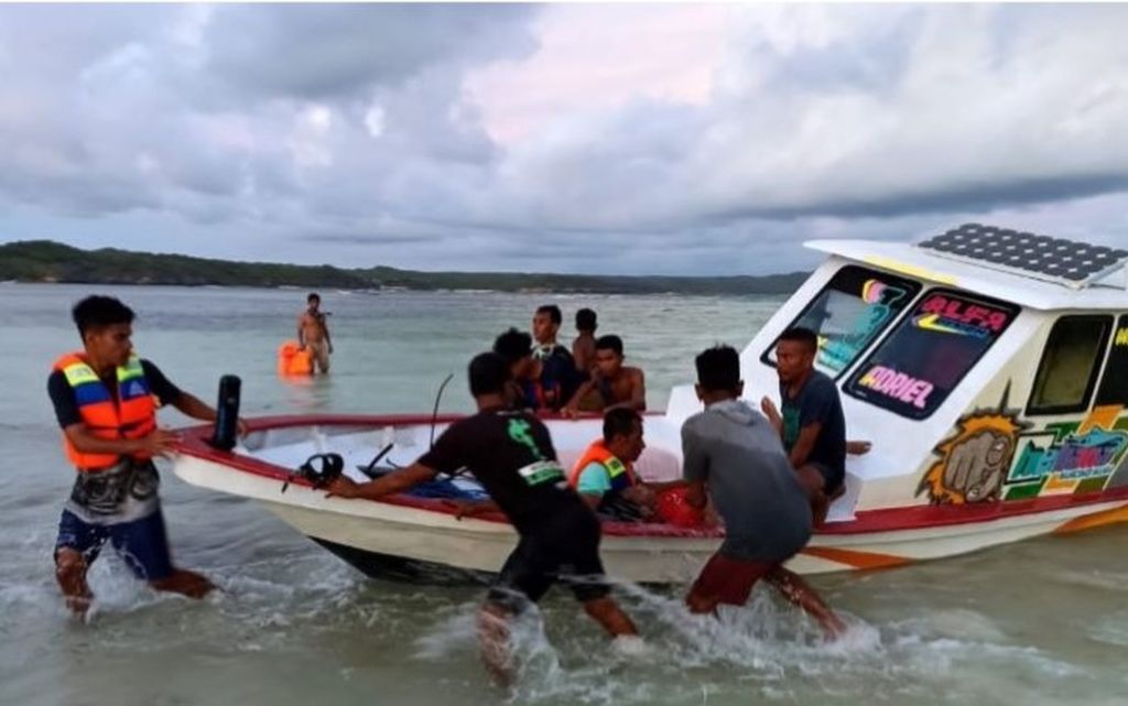 Sebuah kapal motor sedang mengevakuasi warga yang tenggelam saat uji coba perahu motor di Desa Bo'a, Kecamatan Rote Barat, Kabupaten Rote Ndao, Nusa Tenggara Timur, Minggu (16/10/2022). Dalam kejadian ini, tujuh orang tewas, 11 orang dirawat, dan 23 lainnya selamat.
