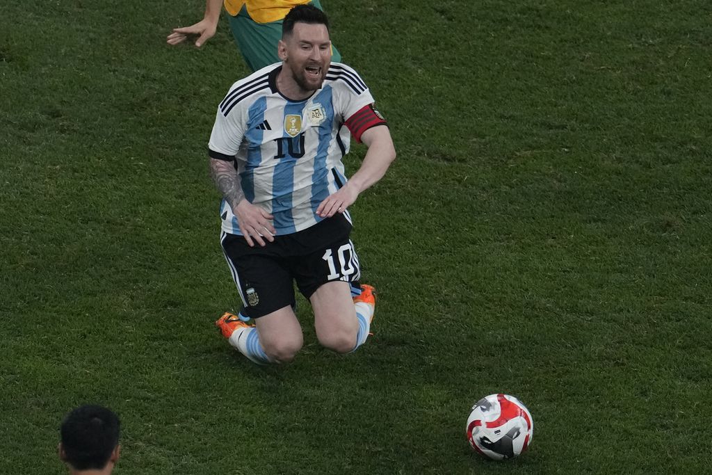 Lionel Messi terjatuh setelah bertubrukan dengan pemain Australia dalam pertandingan persahabatan antara Argentina dan Australia di Stadion Pekerja, Beijing, China, Kamis (15/6/2023). 