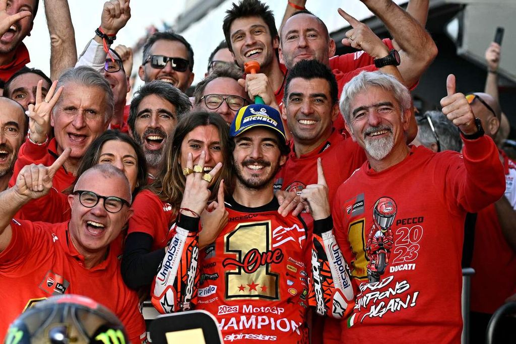Pebalap Ducati Lenovo, Francesco Bagnaia, melakukan selebrasi bersama tim dan tunangannya, Domizia Castagnini (tengah belakang), setelah balapan utama MotoGP seri Valencia di Sirkuit Ricardo Tormo, Cheste, Spanyol, Minggu (26/11/2023). Bagnaia berhasil menjadi juara dunia MotoGP 2023. 