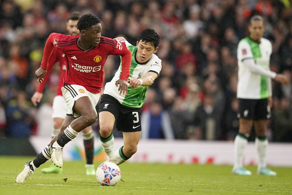 Manchester United player, Kobbie Mainoo (left), vies for the ball with Liverpool player, Wataru Endo, in the quarter-finals of the FA Cup at Old Trafford Stadium, Manchester, Sunday (17/3/2024). MU won 4-3 in that match.