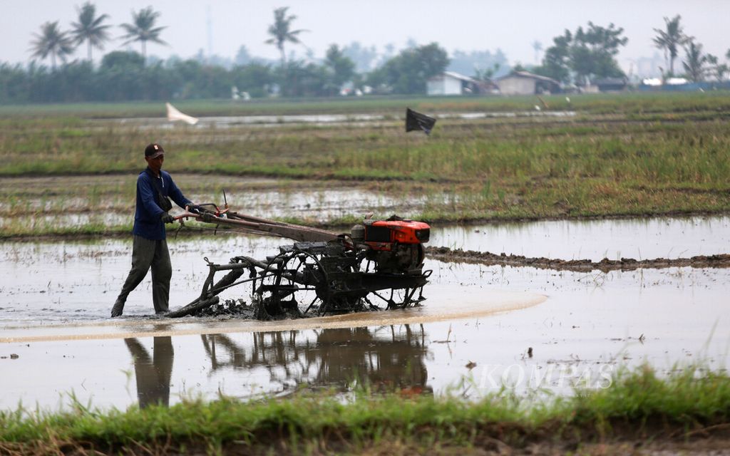 Petani membajak sawah untuk persiapan tahap awal musim tanam di areal persawahan di Pakuhaji, Kramat, Kecamatan Pakuhaji, Kabupaten Tangerang, Banten, Selasa (15/2/2022).