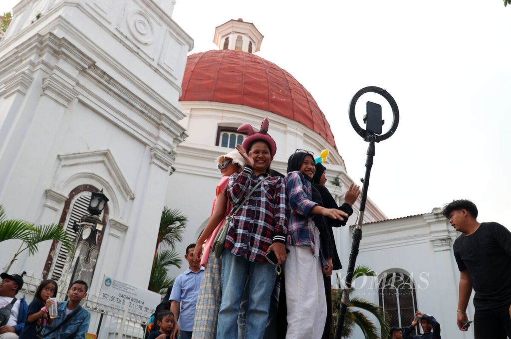 Lapak pojok foto 360 derajat yang disediakan bagi pengunjung untuk bergaya dengan latar belakang Gereja Blenduk di Kota Lama, Kota Semarang, Jawa Tengah, Jumat (10/5/2024). Saat ini tren wisata tidak sebatas mengunjungi sebuah tempat, tetapi juga dengan membuat dokumentasi foto atau video dari beragam perangkat untuk diunggah ke media sosial. 