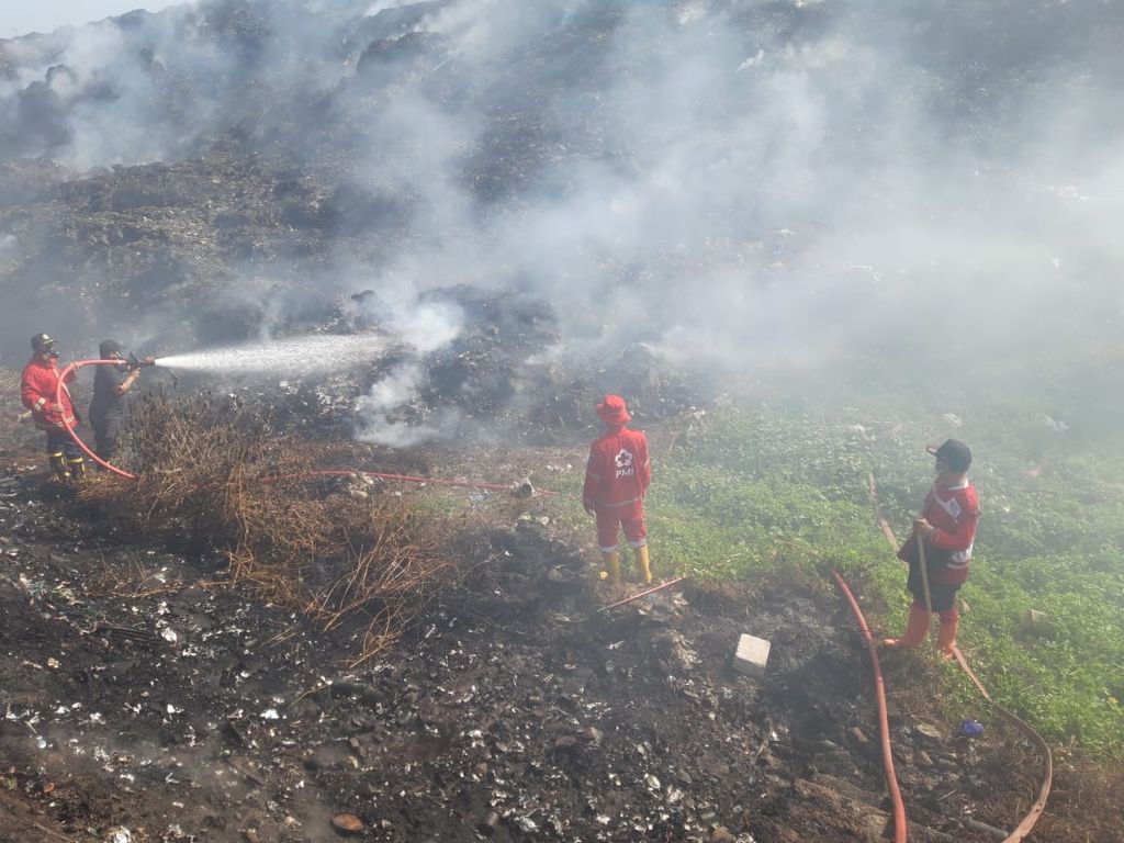 Petugas pemadam kebakaran berupaya mendinginkan bekas titik api di tempat pemrosesan akhir sampah di Desa Penujah, Kecamatan Kedungbanteng, Kabupaten Tegal, Jawa Tengah, Jumat (30/6/2023).