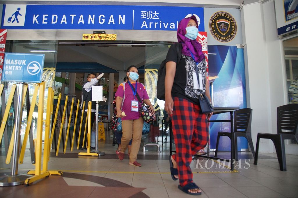Sejumlah pekerja migran Indonesia keluar dari Pelabuhan Batam Centre, Kota Batam, Kepulauan Riau, Selasa (24/3/2020). 
