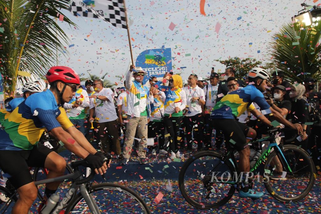 Gubernur Jawa Barat Ridwan Kamil melepas bendera start menandainya dimulainya balap sepeda Cycling de Jabar 2022 di Pantai Palangpang, Kawasan Geopark Ciletuh, Kecamatan Ciemas, Kabupaten Sukabumi, Jawa Barat, Sabtu (27/8/2022).  