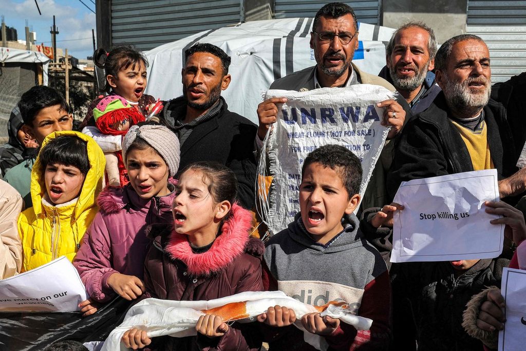Warga dewasa dan anak-anak Palestina berunjuk rasa di Rafah, Jalur Gaza, Selasa (30/1/2024), menyuarakan seruan agar komunitas internasional terus membantu Badan Bantuan Sosial dan Pekerja Perserikatan Bangsa-Bangsa (UNRWA). 
