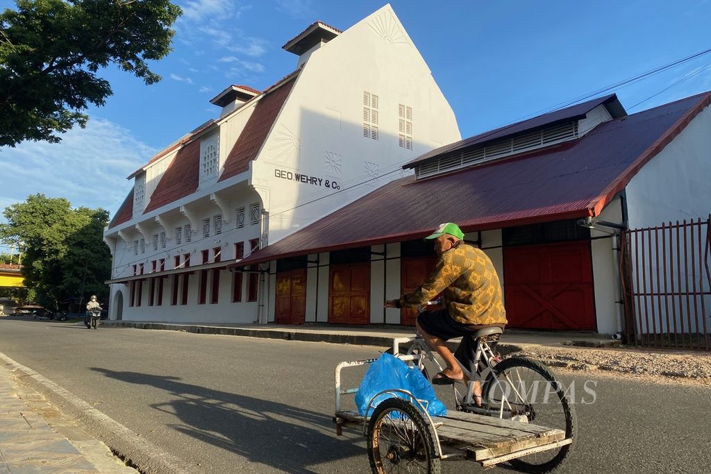 Seorang warga dengan sepeda pembawa barang melintas di depan Gedung Geo Wehry & CO di Kawasan Kota Tua Padang, Kota Padang, Sumatera Barat, Jumat (16/6/2023) pagi. Gedung tersebut adalah salah satu bangunan bersejarah peninggalan zaman kolonial Belanda dan saat ini menjadi bangunan cagar budaya yang dilindungi. 