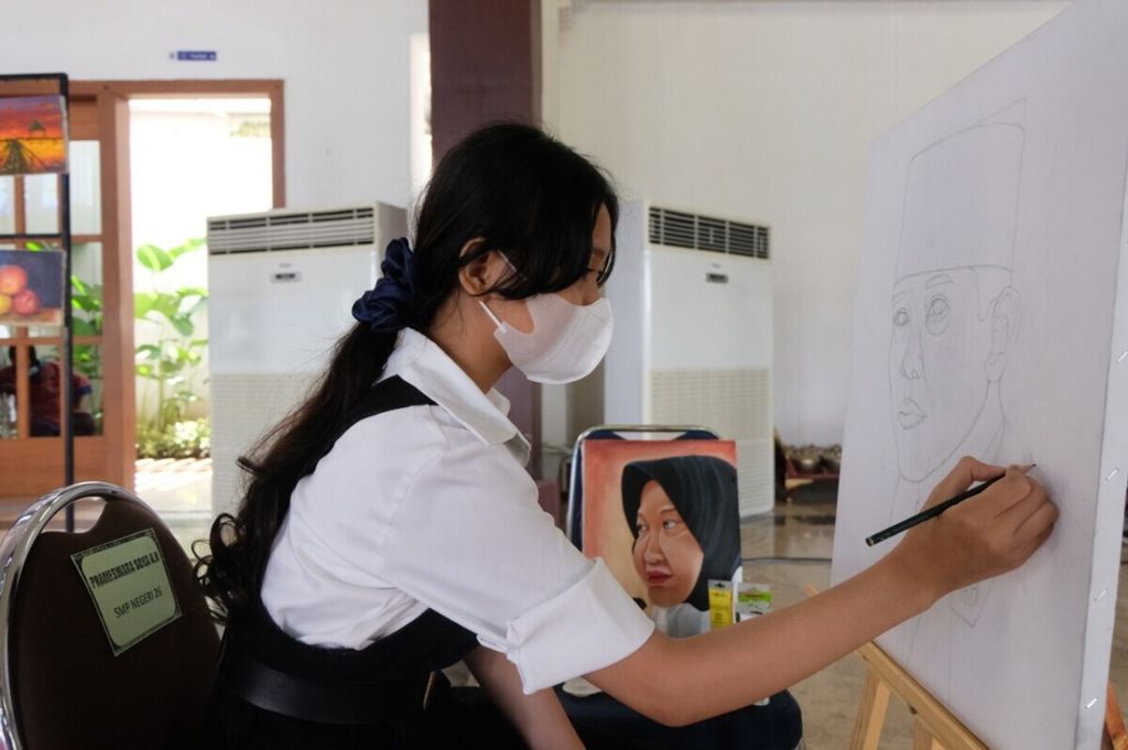 A student paints the figure of her idol during the commemoration of Education Day at Balai Pemuda, Surabaya, East Java, Surabaya (2/5/2021).