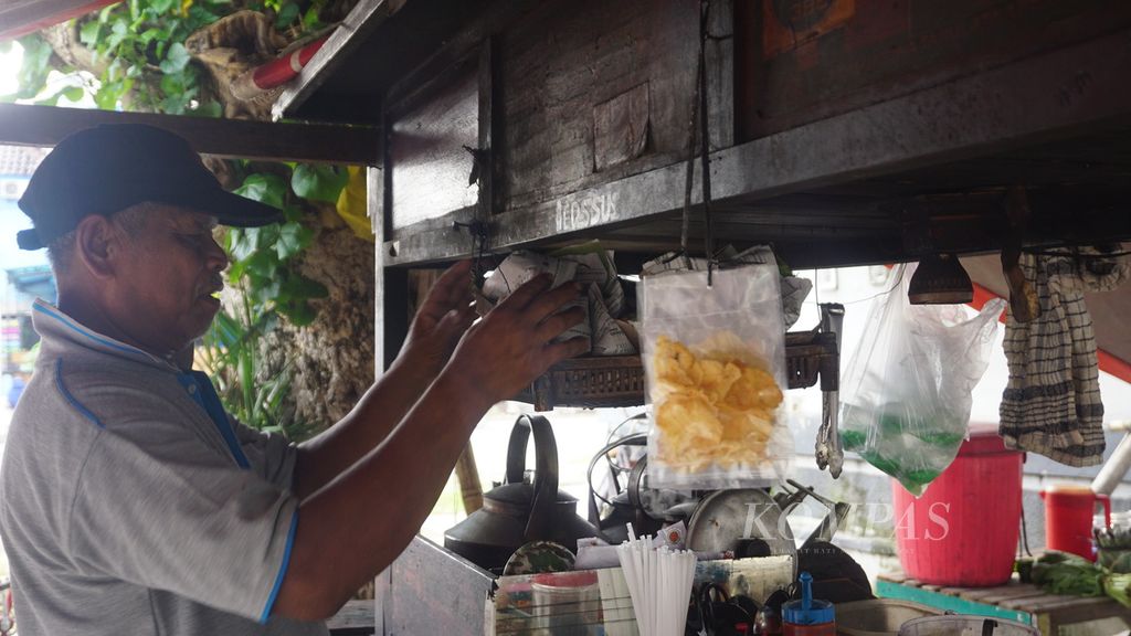 Penjual hik tengah menata nasi bungkus pada gerobak hiknya di Kecamatan Laweyan, Kota Surakarta, Jawa Tengah, Selasa (22/3/2022). Hik bukan sekadar tempat jajan. Tempat itu sekaligus menjadi ruang interaksi sosial bagi warga untuk mencurahkan keresahannya tentang berbagai hal.
