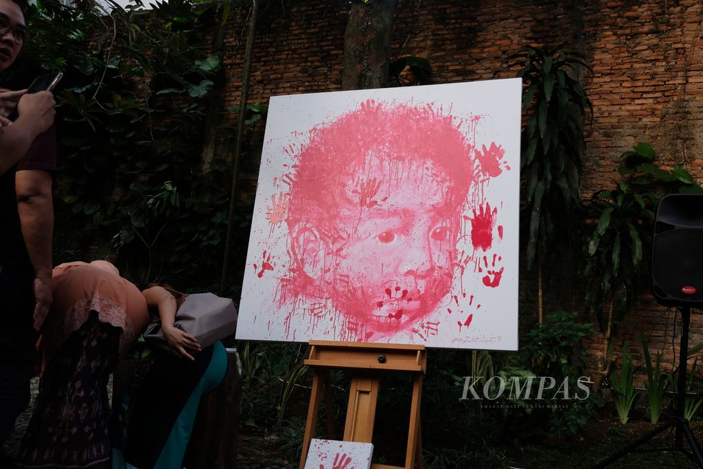 Para pengunjung pameran seni Speak Up memberikan cap tangan di lukisan karya perupa Prajna Dewantara pada Sabtu (22/7/2023) di Jakarta. Cap itu merupakan simbol perjanjian publik untuk bekerja sama menghentikan kekerasan seksual. Adapun pameran Speak Up menampilkan 55 karya seni anak-anak berusia 12-17 tahun yang merespons kekerasan seksual.