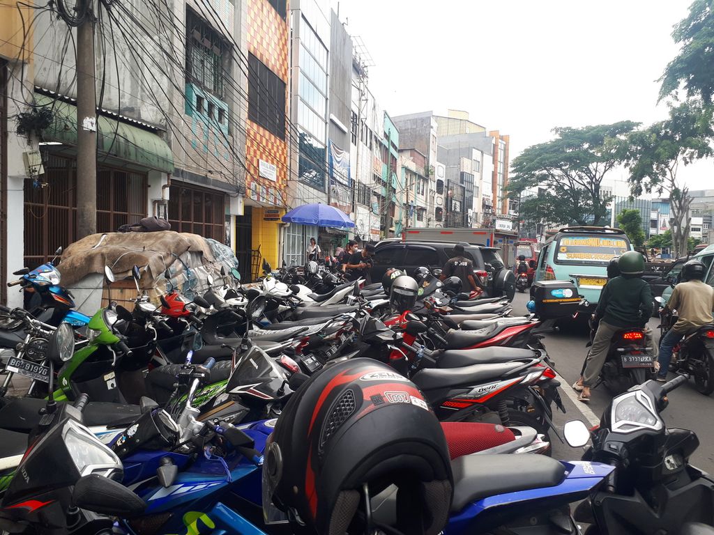 Area trotoar dan badan jalan uang terokupasi untuk parkir motor di Jalan  Pancoran, Glodok, Taman Sari, Jakarta Barat, Selasa (6/12/2022).