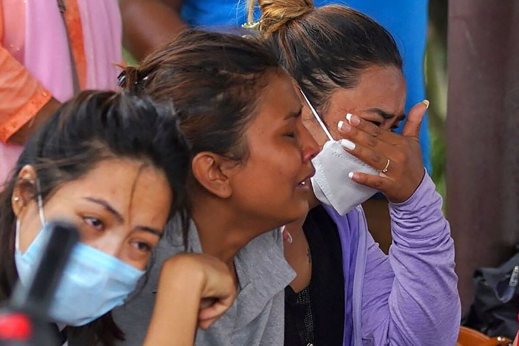 Para anggota keluarga dan kerabat penumpang Twin Otter yang dioperasikan maskapai Nepal, Tara Air, berlinangan air mata saat menanti informasi nasib keluarga mereka di bandar udara di Pokhara, Nepal, Minggu (29/5/2022).