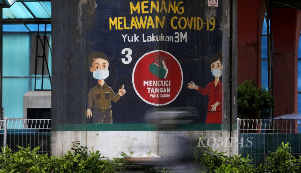 Pengendara melintas di depan mural tentang waspada Covid-19 di kawasan Sunter, Jakarta Utara, Kamis (9/2/2023).