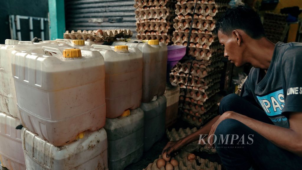 Pekerja menata telur dan jeriken minyak goreng 16 liter di Pasar Pulojae, Cakung, Jakarta Timur, Kamis (6/1/2022). Satu kilogram telur dijual Rp 27 ribu, sedangkan jeriken minyak goreng curah berisi 16 kilogram dijual Rp 290 ribu. Pemerintah akan menggelontorkan minyak goreng kemasan sederhana bersubsidi sebanyak 1,2 miliar liter selama enam bulan ke depan untuk menstabilkan harga minyak goreng. KOMPAS/AGUS SUSANTO (AGS) 6-1-2022