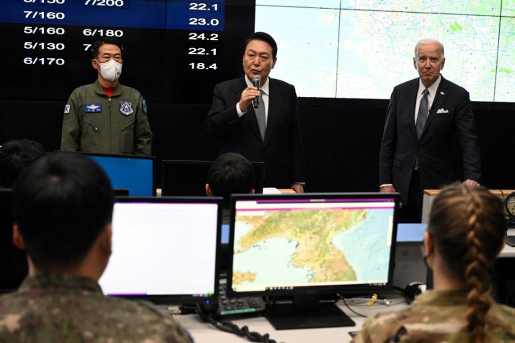 Presiden Korea Selatan Yoon Suk-yeol (tengah) berbicara, didampingi Presiden AS Joe Biden (kanan) dan Letnan Jenderal Sung Chun-choi (kiri), Komandan Komando Operasi Angkatan Udara, Angkatan Udara Korsel, saat mereka berada di Pangkalan Udara Osan di Pyeongtaek, 22 Mei 2022. 