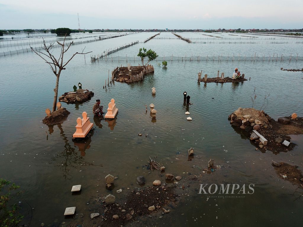 Warga berziarah ke makam yang sebagian kawasannya tenggelam oleh pasang air laut di Desa Tugu, Kecamatan Sayung, Kabupaten Demak, Jawa, Kamis (26/4/2018). 