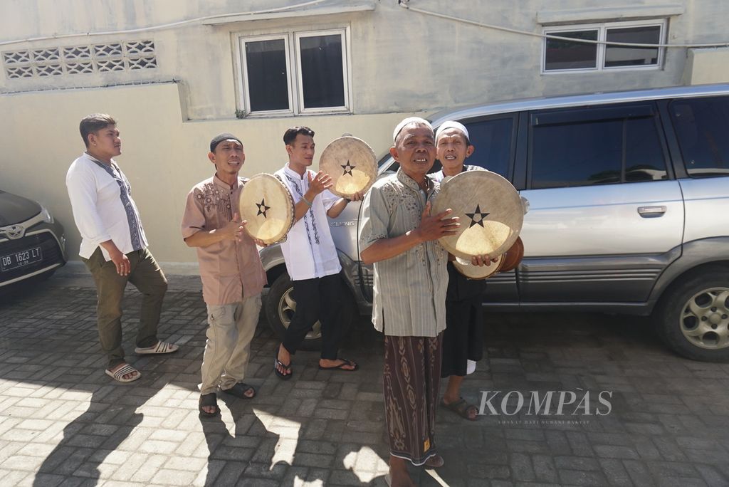 Kelompok hadra dari Masjid Al Ikhlas Karame berkeliling dari rumah ke rumah untuk mengumpulkan sumbangan bagi masjid di Kelurahan Istiqlal, Manado, Sulawesi Utara, pada Idul Fitri 1443 Hijriah, Senin (2/5/2022). Kegiatan yang mereka sebut tawaf itu adalah tradisi turun-temurun yang mereka laksanakan setiap tahun.