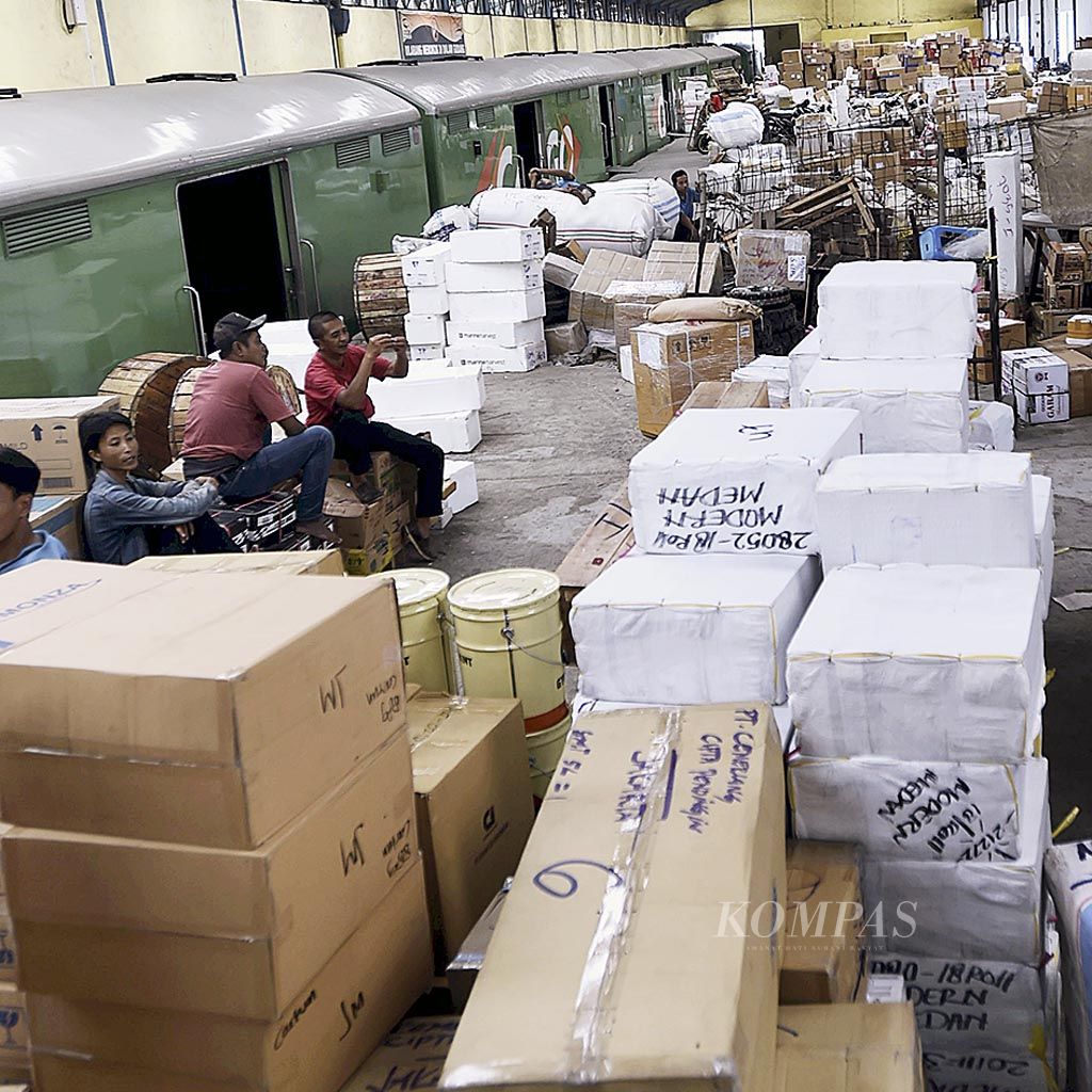 Pekerja duduk  di antara barang-barang di Stasiun Kereta Angkutan Barang Pasar Turi di Surabaya, Jawa Timur, Selasa (13/6). Menurut Ryan, salah seorang pekerja, pengiriman barang melalui kereta menjelang Lebaran meningkat dibandingkan hari-hari biasa. 