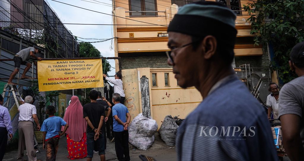 Suasana warga Jalan Tanah Tinggi I Gang 5, Johar Baru, Senen, Jakarta Pusat, bersama-sama memasang spanduk penolakan penggantian nama jalan di wilayah permukiman mereka, Rabu (29/6/2022).