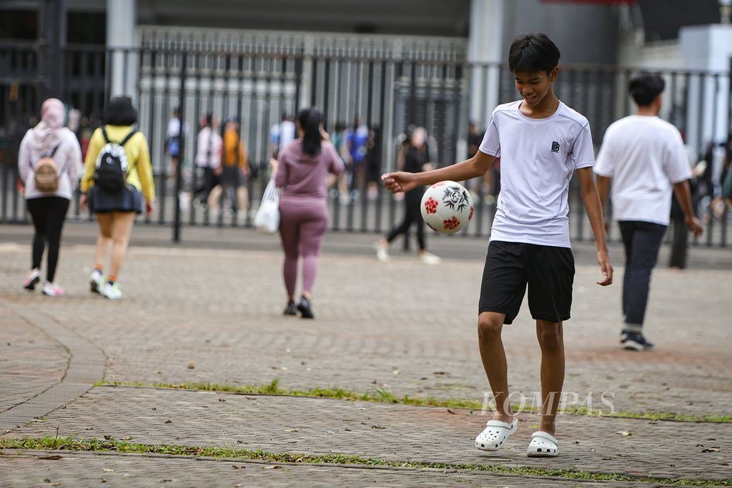 Warga bermain bola di kawasan Gelora Bung Karno, Jakarta, Jumat (16/2/2024). Menurut penelitian yang dipublikasikan di <i>The British Medical Journal</i>, berolahraga, seperti berjalan kaki, joging, yoga, dan latihan kekuatan fisik, dapat membantu meredakan depresi. 