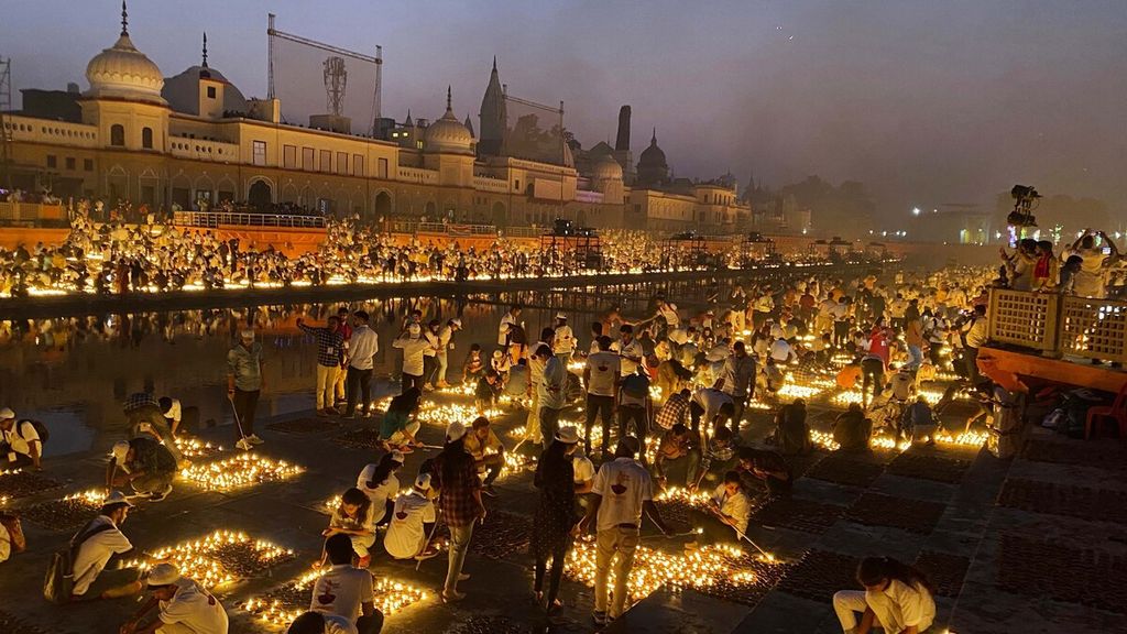 Warga menyalakan lampu minyak atau diyas di tepi Sungai Saryu, Kota Ayodhya, India, Rabu (3/11/2021). Kota Ayodhya mencetak rekor dunia baru untuk penyalaan diyas dengan jumlah terbanyak. Sebanyak 9 lakh diyas atau setara dengan 900.000 diyas menyala menerangi tepian Sungai Saryu selama 45 menit.