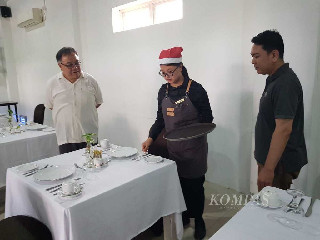 Darmawan Sunarja, Kepala SMK Pariwisata Metland (kiri), memandu siswanya menata meja restoran di gedung SMK Metland, Cileungsi, Bogor, Jawa Barat, Senin (18/12/2023). 