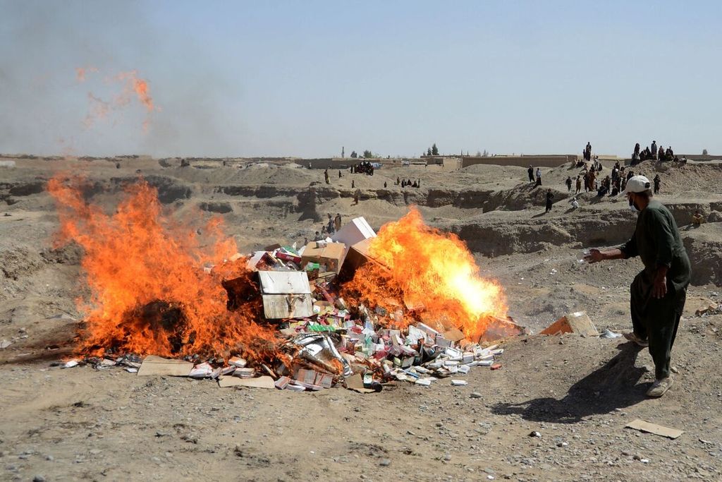 Seorang petugas kesehatan tengah membakar obat-obatan yang telah kadaluwarsa di sebuah tanah lapang di luar kota Kandahar pada Rabu (16/3/2022).