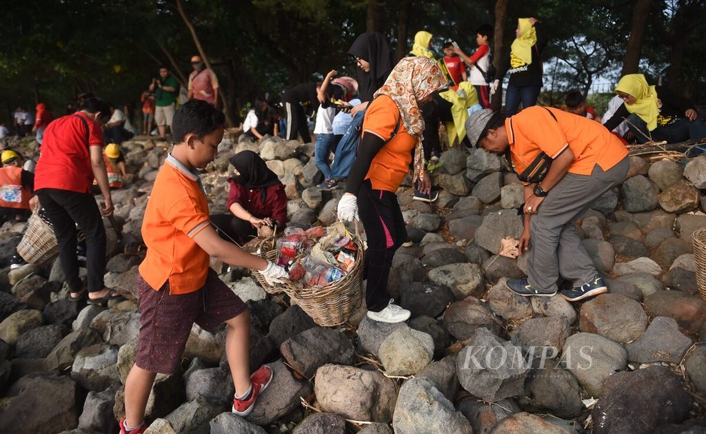 Warga memungut sampah di Pantai Nambangan, Surabaya, Jawa Timur, Minggu (4/6/2023).  