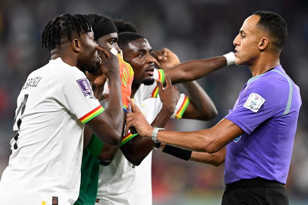 Wasit asal Amerika Serikat, Ismail Elfath (kanan), berbicara dengan para pemain Ghana di tengah pertandingan Grup H Piala Dunia Qatar 2022 antara Portugal dan Ghana di Stadion 974, Doha, Qatar, Kamis (24/11/2022).