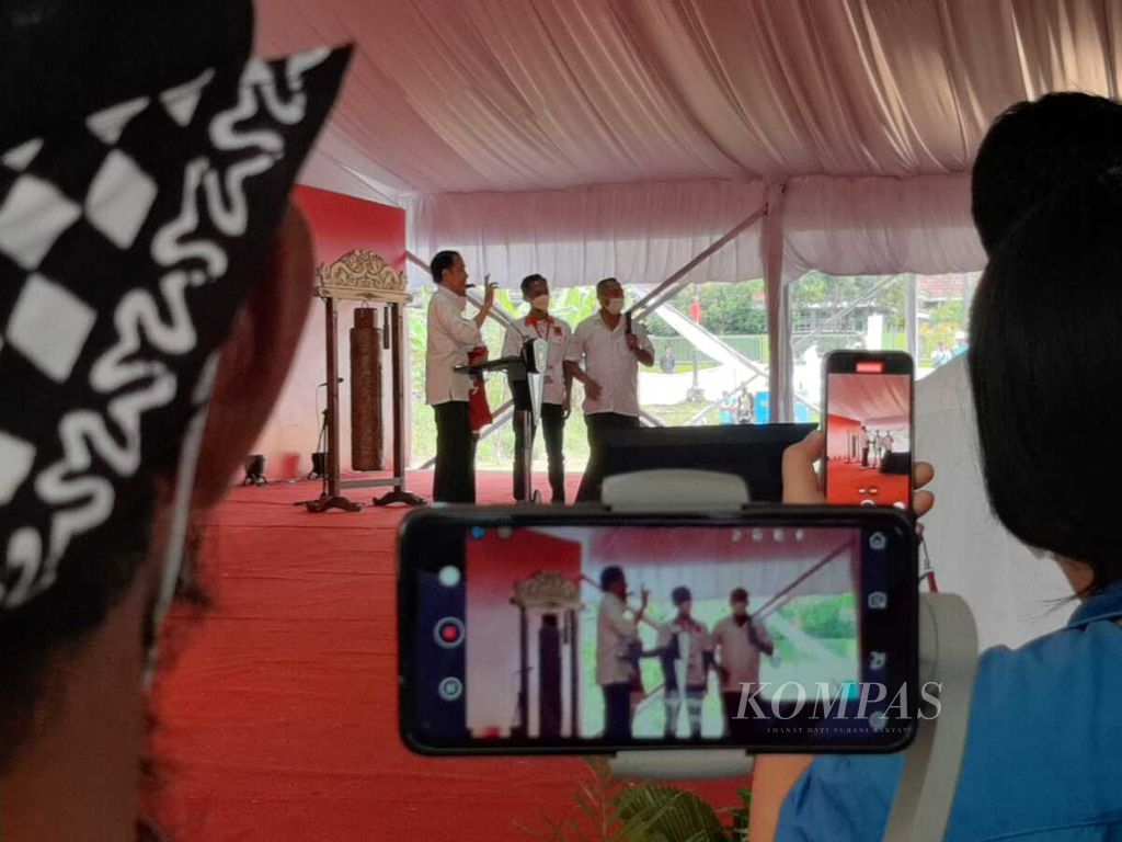Presiden Joko Widodo saat berbincang sebelum memberikan jaketnya kepada relawan pendukung pada pembukaan Rapat Kerja Nasional V Projo di Balai Ekonomi Desa (Balkondes) Ngargogondo, Magelang, Provinsi Jawa Tengah, Sabtu (21/5/2022).