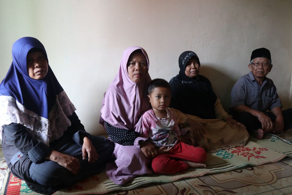 Carmi (kiri), mantan pekerja migran Indonesia, berfoto bersama keluarganya di Desa Rawaurip, Kecamatan Pangenan, Kabupaten Cirebon, Jawa Barat, Jumat (5/2/2021). Carmi bekerja di Arab Saudi selama 31 tahun dan putus kontak dengan keluarga. Setelah kembali ke Cirebon, Carmi harus beradaptasi lagi.