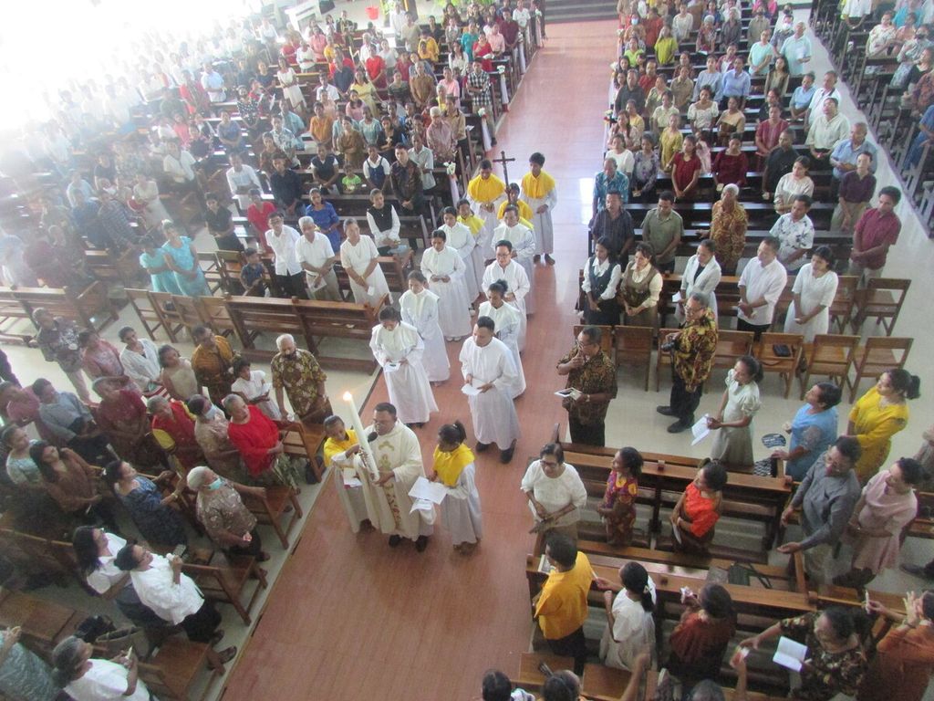 Pastor Paulus Madoni CFM sebagai pemimpin misa mengarak lilin Paskah menuju altar sebagai simbol kebangkitan Tuhan di Gereja Katolik Santo Yoseph Pekerja, Penfui, Kupang, Sabtu (30/3/2024). 