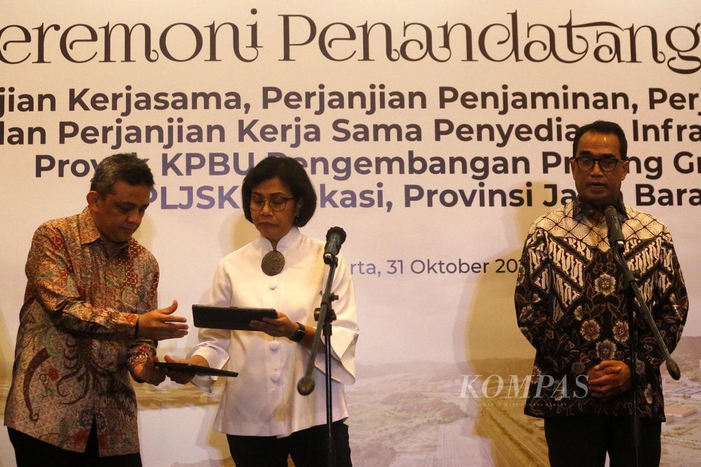 Menteri Keuangan Sri Mulyani Indrawati (tengah) dan Menteri Perhubungan Budi Karya Sumadi (kanan) memberi keterangan seusai penandatanganan perjanjian Kerja Sama Pemerintah dan Badan Usaha (KPBU) pengembangan <i>proving ground </i>balai pengujian laik jalan dan sertifikasi kendaraan bermotor (BPLJSKB) di Jakarta, Senin (31/10/2022). 