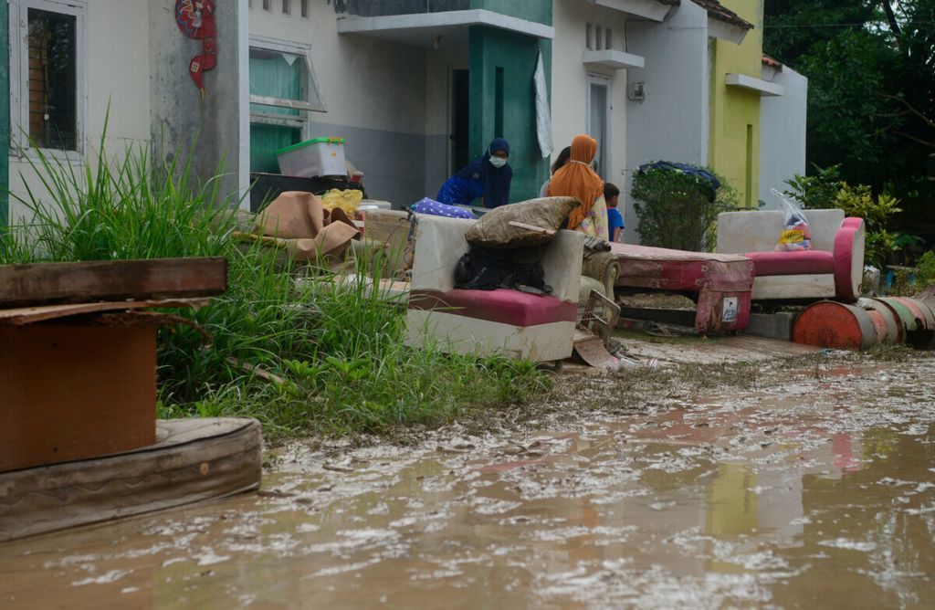 Warga mengeluarkan seluruh perabot rumahnya setelah terendam banjir bandang yang terjadi di Perumahan Dinar Mas, Kecamatan Tembalang, Kota Semarang, Jawa Tengah, Senin (18/1/2021). Banjir sedalam satu meter lebih itu menyebabkan rusaknya perabot rumah tangga milik warga.