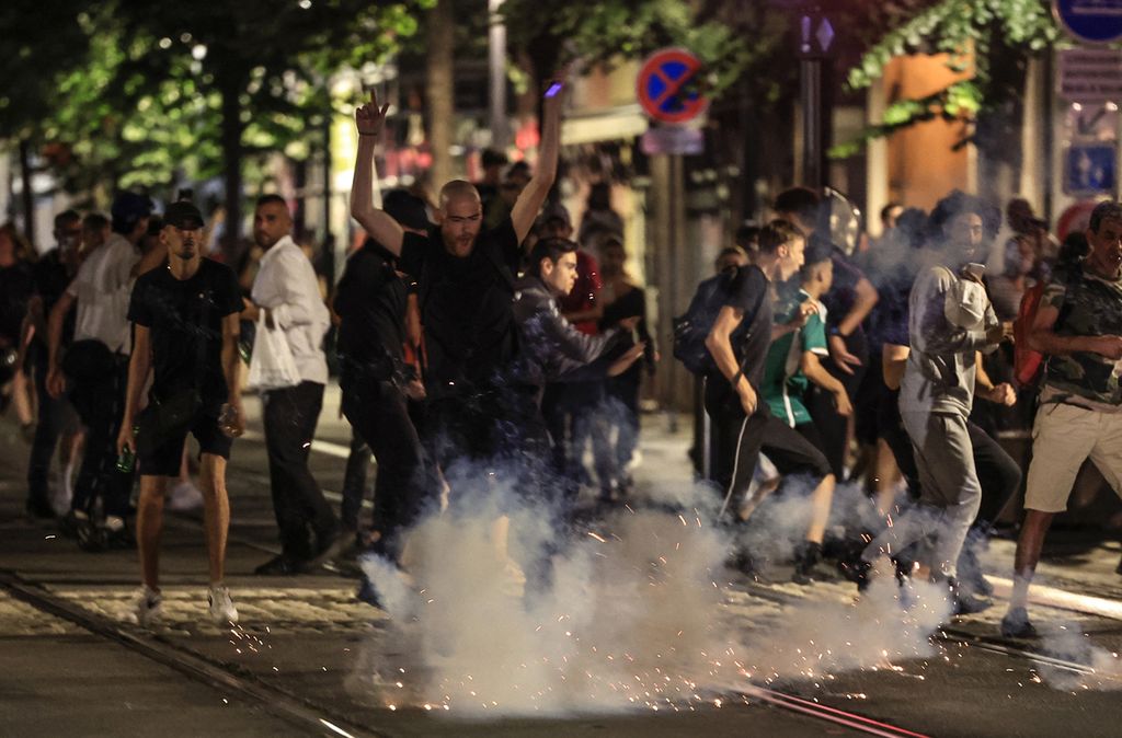 Para pengunjuk rasa melarikan diri dari kembang api yang meledak di sebuah jalan di Nice, Perancis tenggara, pada awal 2 Juli 2023, pada malam kelima kerusuhan setelah penembakan seorang pengemudi remaja di Nanterre, pinggiran Paris, pada 27 Juni. 
