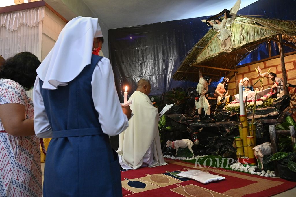 Romo Pius Pujowiyanto SCJ memimpin doa di hadapan patung bayi Yesus dalam misa malam Natal di Gereja St Teresia Jambi, Sabtu (25/12/2022). 