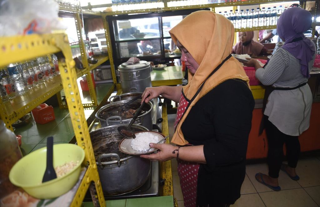 (Pesanan Kompas Minggu) Pekerja menyiapkan pesanan di warung rawon balungan Benowo H Mufid saat jam makan siang di Surabaya, Jawa Timur, Rabu (13/9/2023). Usaha rawon balungan tersebut berdiri sejak tahun 1965. 