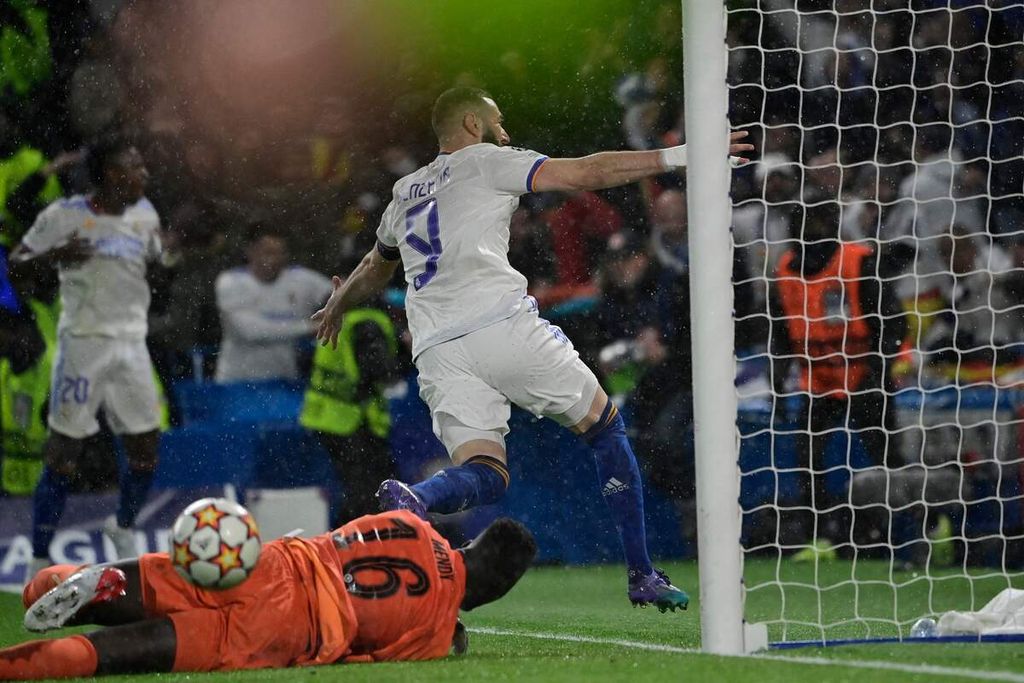 Striker Real Madrid, Karim Benzema (atas), merayakan keberhasilannya mencetak gol setelah melewati kiper Chelsea, Edouard Mendy, pada laga pertemuan pertama babak perempat final Liga Champions Eropa di Stadion Stamford Bridge, London, Inggris, Kamis (7/4/2022) dini hari WIB. Real menang, 3-1.