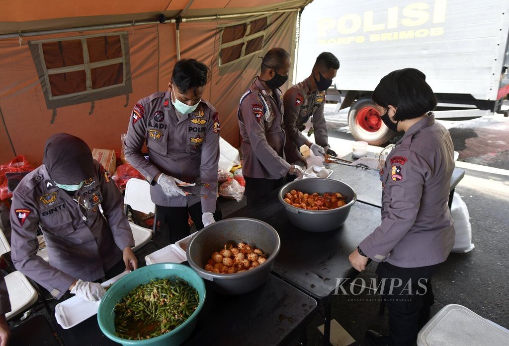 Anggota Korps Brimob Polri menyiapkan sayur, lauk, dan nasi putih dalam kotak di dapur umum TNI/Polri untuk penanganan pandemi Covid-19 di kawasan Kota Tua, Jakarta Barat, Kamis (16/4/2020). Dapur umum tersebut setiap hari menyiapkan 800 nasi kotak yang dibagikan kepada warga sebanyak dua kali dalam satu hari. 